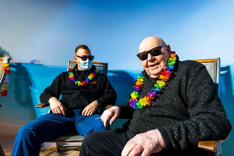 Två män med solglasögon sitter i var sin solstol. 