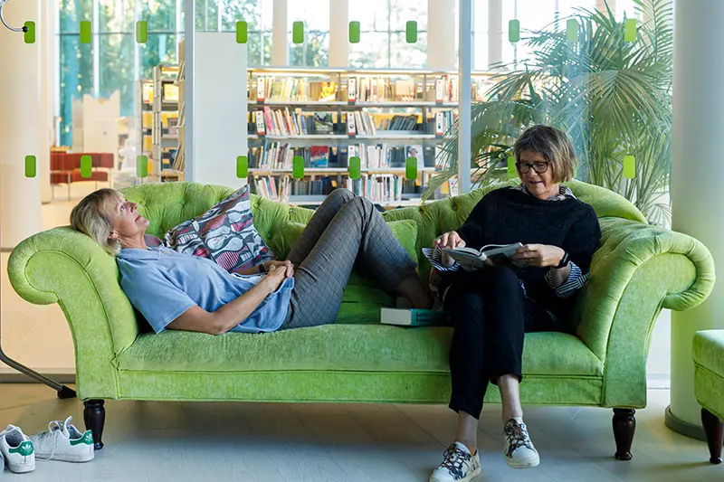 Två kvinnor ligger i en soffa på Stadsbiblioteket. 