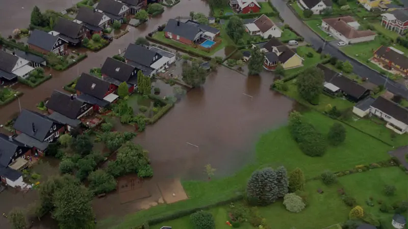 Flygfoto över Getinge där det är vatten på gatorna runt husen och en lekplats ligger under vatten.