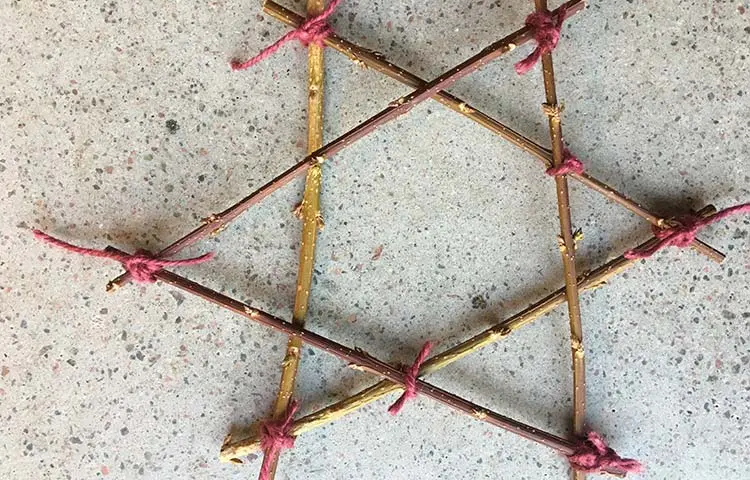 En stjärna av pinnar som är ihopknutna med rosa band.