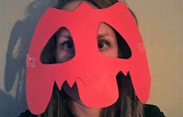 En kvinna har en röd monstermask på sig.