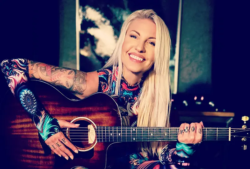 Blond kvinna med gitarrr