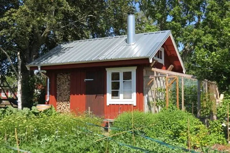 Attefallshus och bakstugan Komfusenbo i Harplinge är en liten röd stuga med vita knutar.
