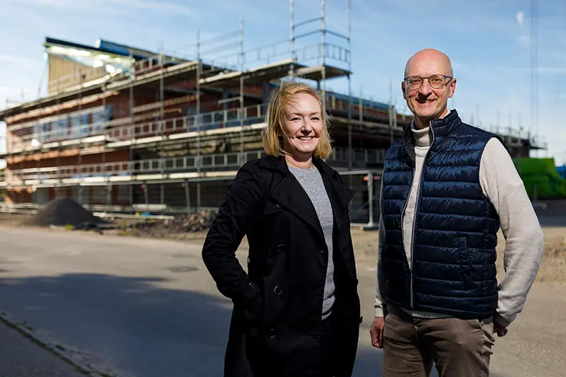 Nina Sanell och Stefan Agmarken framför bygget av nya Fyllingeskolan.